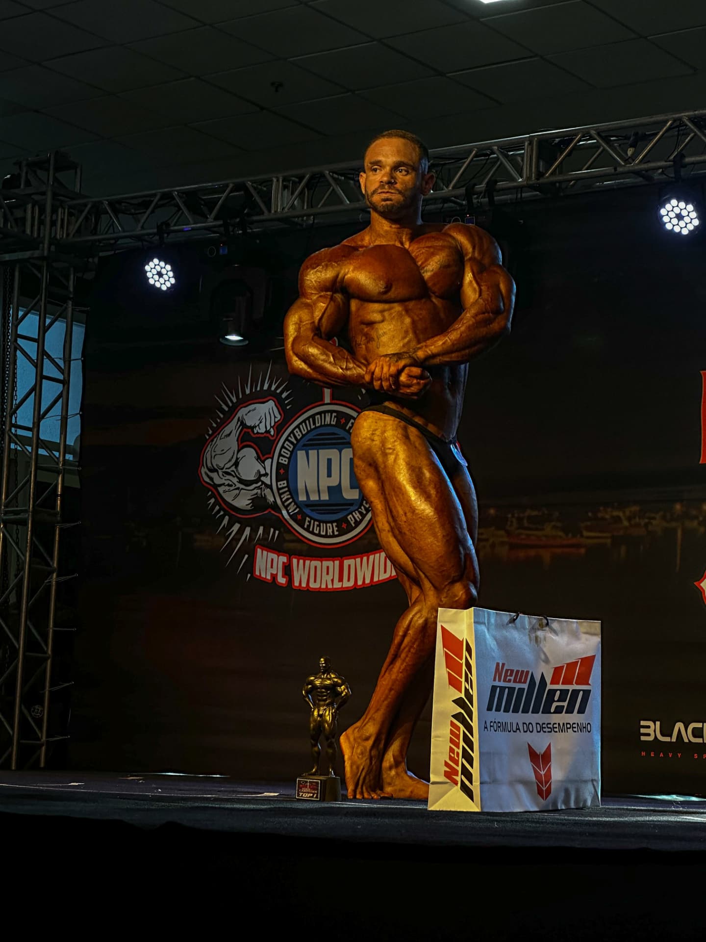 Matheus Antunes no palco de um campeonato NPC de fisiculturismo